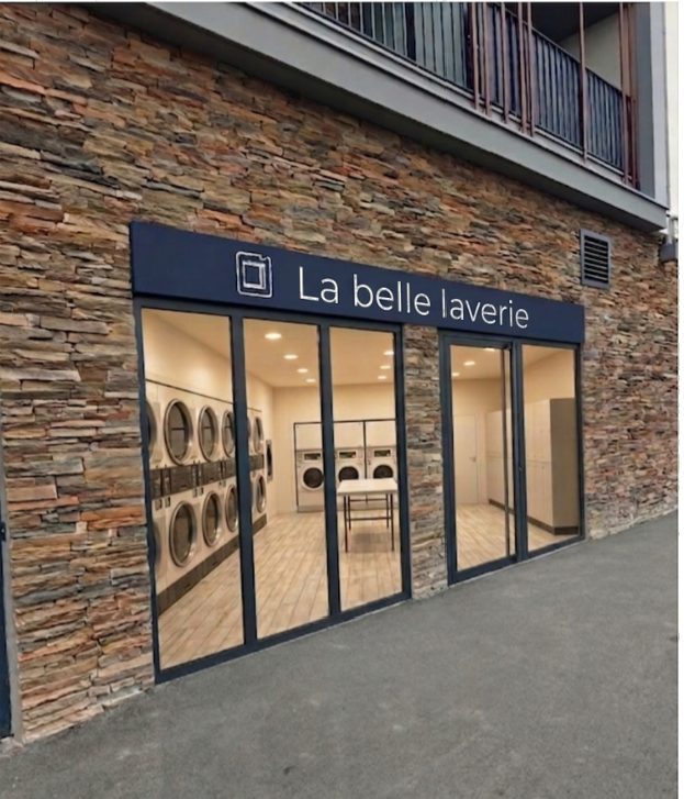 Devanture de La Belle Laverie, laverie automatique à Chennevières-sur-Marne : façade en pierre, enseigne bleu marine et machines à laver Electrolux visibles derrière les vitrines